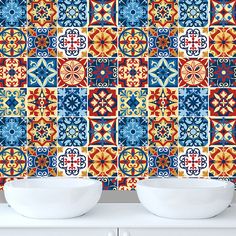 two bowls are sitting in front of a colorful tile wall