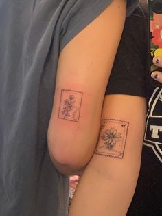 two people with matching tattoos on their arms