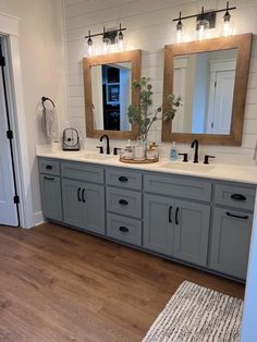 a bathroom with double sinks and two mirrors