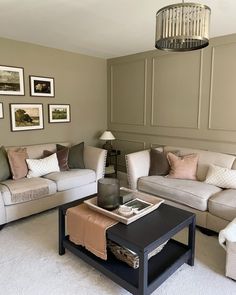 a living room filled with furniture and pictures on the wall