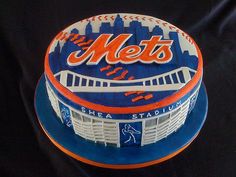 a cake with the name mets on it and an image of a stadium in the background