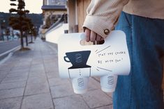 a man is holding a coffee cup shaped sign