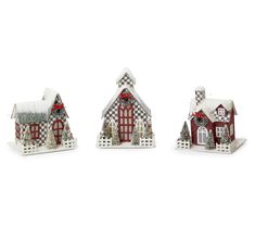 three small houses are decorated with red and white christmas decorations, one has a checkered roof