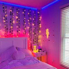 a bed room with a neatly made bed next to a night stand and window covered in lights