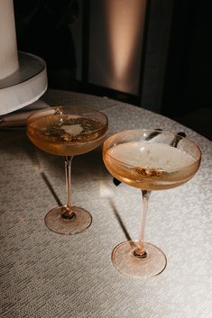 two champagne glasses sitting on top of a table