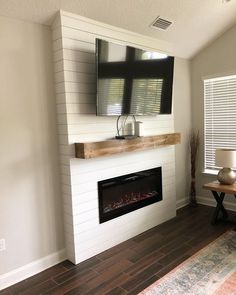 a living room with a fireplace and television mounted on the wall