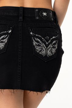 Mid-rise, black mini skirt- Embroidered wing design with rhinestone rivets and sequin detailing- Raised leather appliqué with intricate silver stitching - Embossed black studded leather cross Miss Me brand patch - Frayed bottom hems- 5-pocket designModel is wearing size: SModel Measurements:Height: 5'9"Bust: 32"Waist: 26"Hips: 35"Fabric Content: 99% Cotton 1% ElastaneCare: Gentle machine wash inside-out with like colors in cold water. Tumble dry low.Style No. M3080N69-B01 Wing Design, Wings Design, Leather Cross, Black Mini Skirt, Studded Leather, Black Mini, Miss Me, Cold Water, Mini Skirt