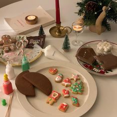 a white plate topped with cookies next to a christmas tree and other holiday treats on a table