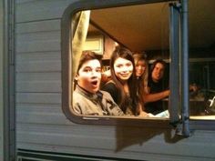 a group of young people are seen through the window of a mobile home at night