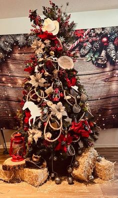 a decorated christmas tree in front of a wooden wall