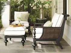 two chairs and a table with flowers on them in front of a door way that leads to an outdoor sitting area