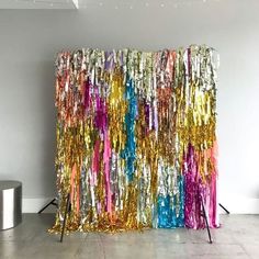 a large curtain made out of colorful tinselic foils in an empty room