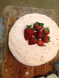 there is a cake with strawberries on the top and frosting in the middle