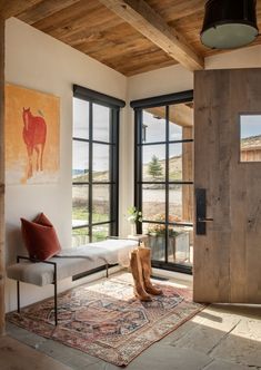 a living room filled with furniture and lots of windows next to a wooden door that leads to a patio