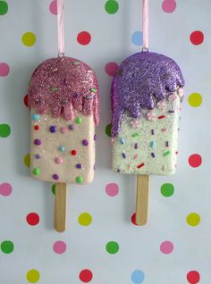 two popsicles decorated with sprinkles and toppings