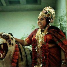 a woman in costume standing next to a tiger