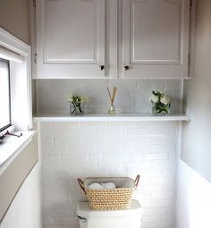 a white toilet sitting in a bathroom next to a window with flowers on the ledge