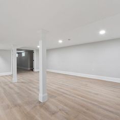 an empty room with white walls and wood floors