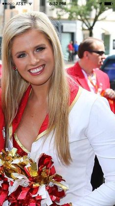 two women dressed in cheerleader outfits standing next to each other and smiling at the camera