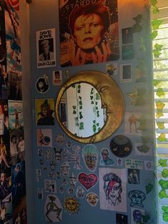 a wall covered in pictures and magnets with a mirror