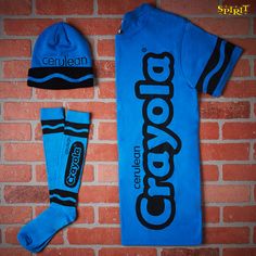 a blue shirt, hat and socks are laying against a brick wall