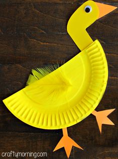 a paper plate with a yellow duck on it sitting on top of a wooden table