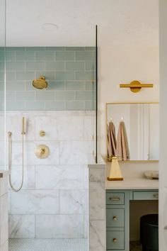 a bathroom with marble counter tops and gold fixtures on the shower wall, along with an open vanity area