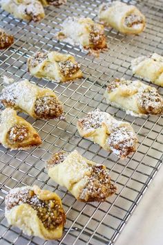 pastries on a cooling rack with powdered sugar and raisins in them