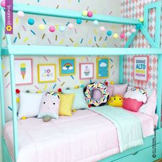 a child's bed with lots of pillows and decorations on the wall above it