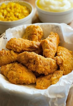 fried chicken in a basket with corn on the side