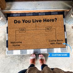 a person standing next to a door mat that says do you live here?