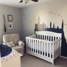 a baby's room with a white crib and a castle mural on the wall