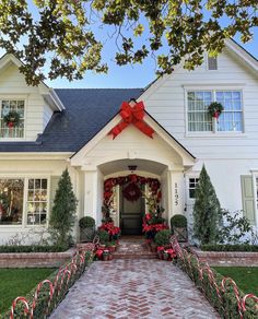 a house decorated for christmas with candy canes and wreaths on the front door