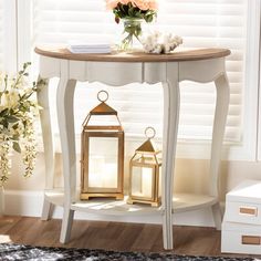 a white table with flowers and two lanterns