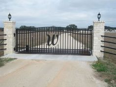 a gate with the number 50 painted on it is in front of a dirt road