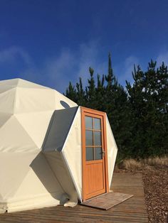 a white yurt sitting on top of a wooden deck