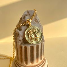 a gold coin is sitting on top of a small statue with a chain around it