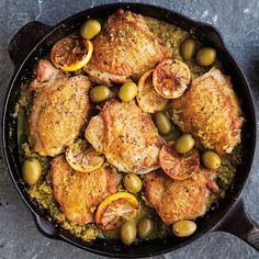 a pan filled with chicken, olives and bread