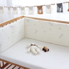 a stuffed animal laying on top of a white crib