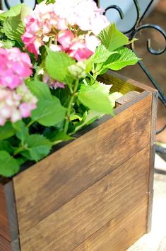 a wooden box filled with pink and white flowers