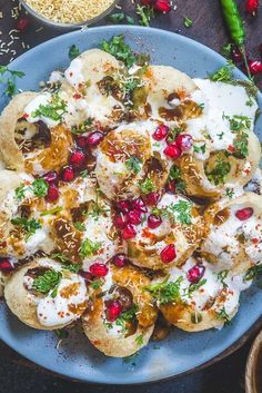 a blue plate topped with pita bread covered in sour cream and pomegranate