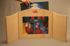 a person holding an open wooden frame with pictures on it