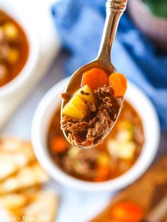 a spoon full of beef stew with carrots and potatoes