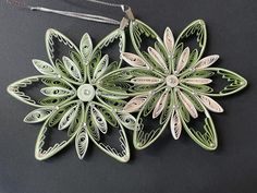 an ornament made out of metal with green and white flowers on the side