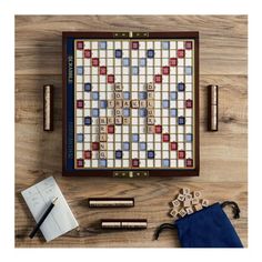 a scrabble board and some pens on a wooden table next to pencils