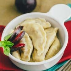 a white bowl filled with dumplings on top of a red and green place mat