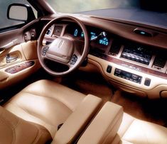 the interior of a car with tan leather seats and dashboard controls, including steering wheel