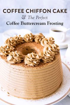 a frosted cake on a plate next to a cup of coffee and saucer