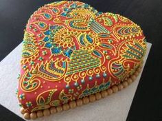 a decorated heart shaped cake sitting on top of a table