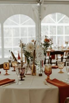 the table is set up with wine glasses and place settings for guests to sit at